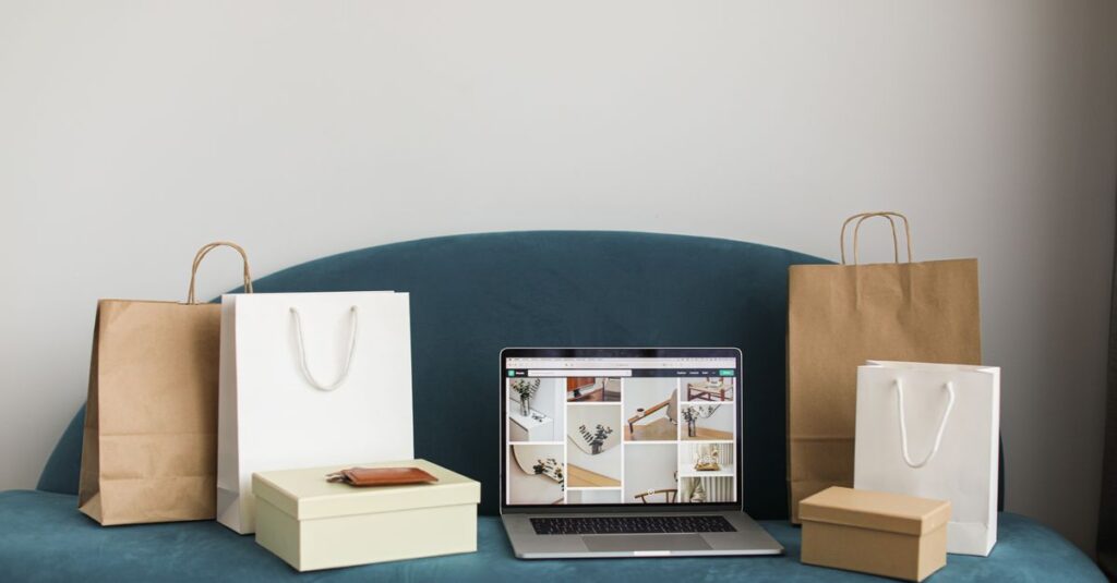 A laptop surrounded by shopping bags and boxes on a blue sofa, ideal for online shopping themes.
